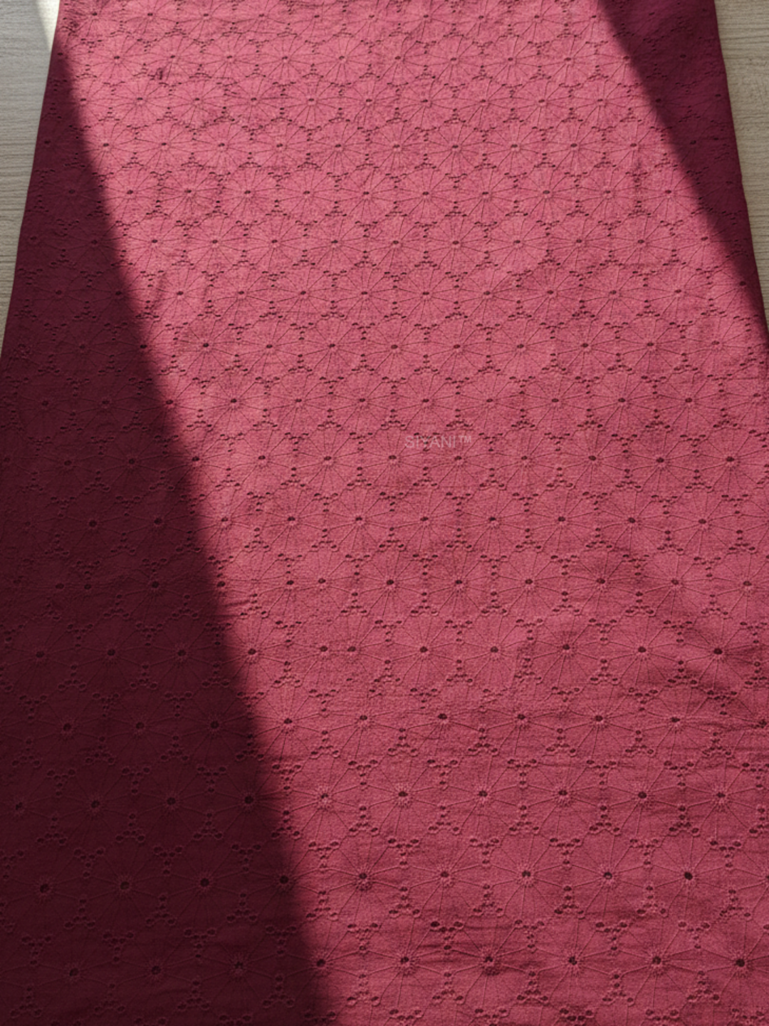 Maroon schiffli eyelet embroidered cotton fabric with geometric floral pattern