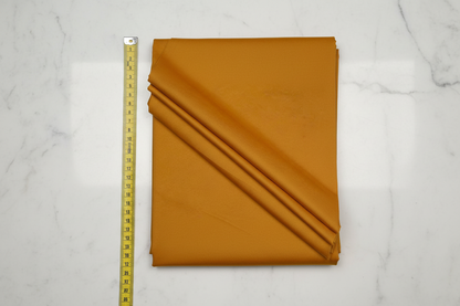 Flat lay of Mustard Cotton Poplin Lycra Fabric with measuring tape showing 44 inch width