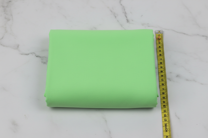 Flat lay of Lime Green Cotton Poplin Lycra Fabric with measuring tape showing 44 inch width