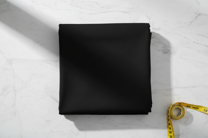 Flat lay of Black Cotton Poplin Lycra Fabric with measuring tape showing 44 inch width