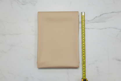 Flat lay of Beige Cotton Cambric Fabric with measuring tape showing 44 inch width
