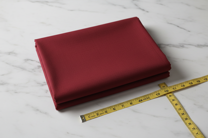 Flat lay of Maroon Cotton Cambric Fabric with measuring tape showing 44 inch width