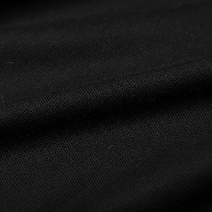 Extreme macro close-up of black jam cotton fabric showing ribbed twill weave structure and thread detail