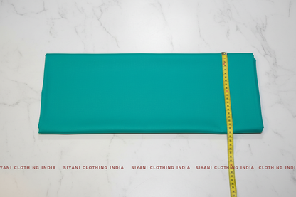 Flat lay of Teal Cotton Poplin Lycra Fabric with measuring tape showing 44 inch width