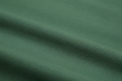 Close-up macro shot of Bottle Green Cotton Poplin Fabric showing fine plain weave texture